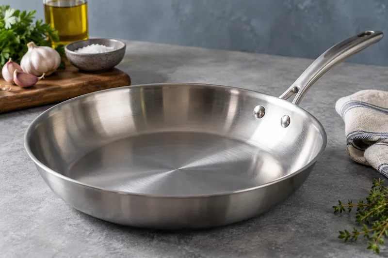The reflective interior and riveted handle of a stainless steel pan